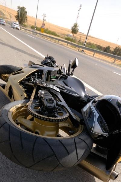 crashed motorcycle laying on side of road