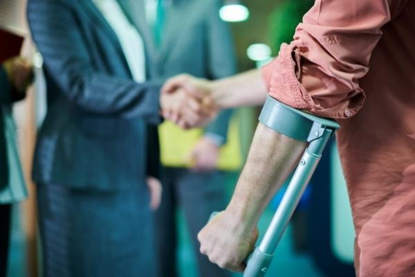 Injured victim shakes hands with personal injury attorney
