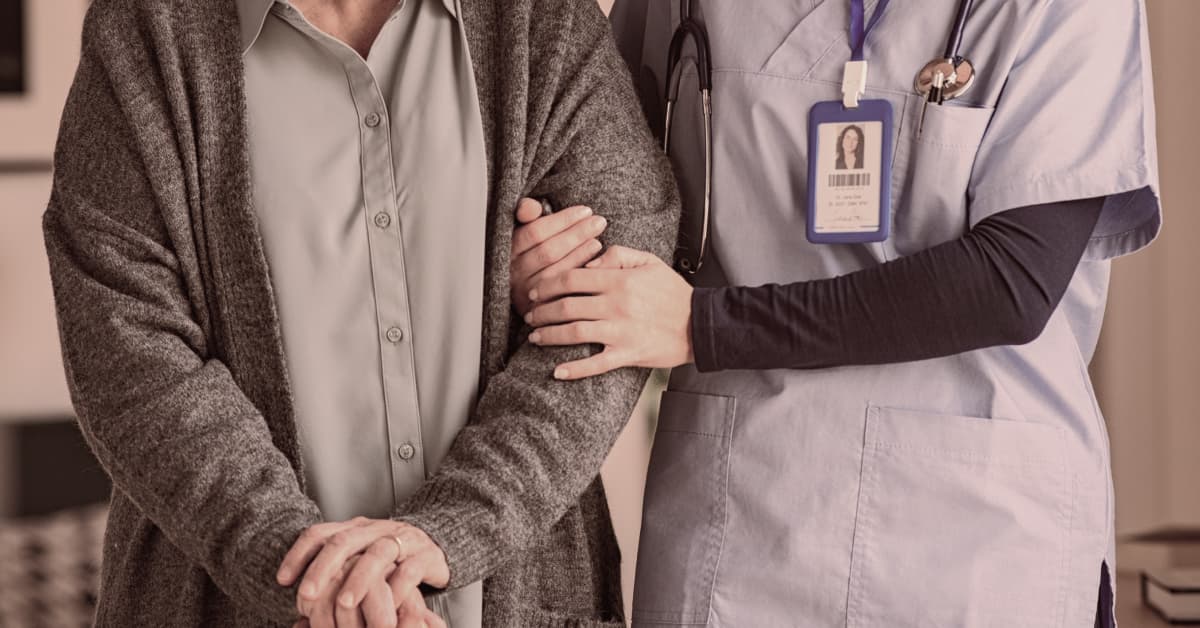 Nurse holding elderly arm depicting Nursing Home Abuse Practice Area at Alexander Shunnarah Trial Attorneys