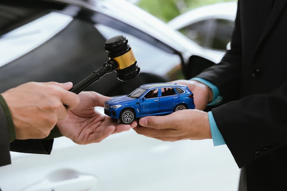 In a courtroom, a judge presides over a car accident claim. The nervous driver awaits the verdict as lawyers present evidence to support their arguments.