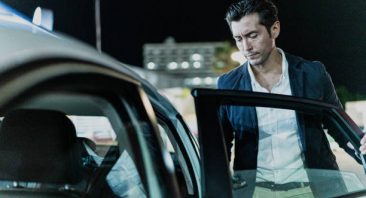 Mid adult businessman entering on a cab after work at city