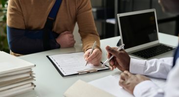 An accident lawyer reviews a contract with a client in Huntsville, Alabama.