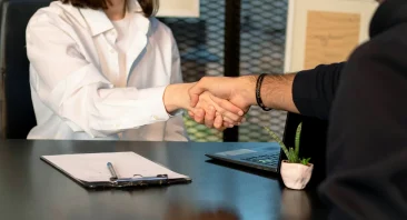 An Alabama accident attorney sits across from an injured client at a law office, reviewing documents during a free case review consultation.