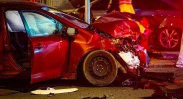 A damaged car sits at the scene of an Alabama car accident. This is when someone would need an attorney.
