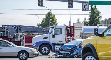 Damaged cars sit at an intersection after a semi truck accident. This is when someone would need an Alabama truck accident attorney.