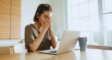 A frustrated policyholder reviews a denied insurance claim letter at a kitchen table, a common sign of bad faith insurance practices.