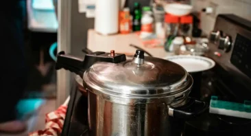 A pressure cooker sits on a stove in a man's kitchen; if it breaks and hurts him, he may need a Birmingham product defects attorney.