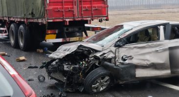 The photo depicts a car damaged from an accident with a truck; the driver would need a truck accident attorney.