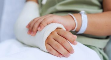 A patient clutches their bandaged arm, illustrating the concept of a burn degree classification.