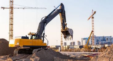 A construction dump truck and excavator operating at a work zone. Construction vehicle accidents may involve multiple liable parties.
