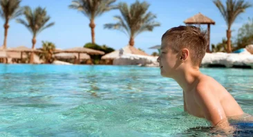 A child swims in a resort pool. This situation could quickly turn into one where someone needs a pool accident lawyer.