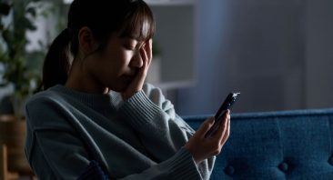 A person reading a damaging false post on a phone, illustrating a defamation-of-character claim.
