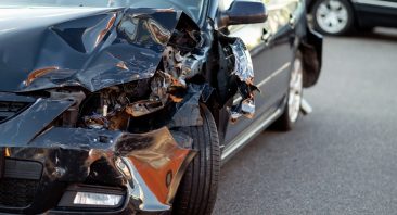 Close-up of damaged car part after accident showing broken metal and scratches