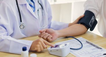 A doctor takes a patient’s blood pressure during an independent medical examination.