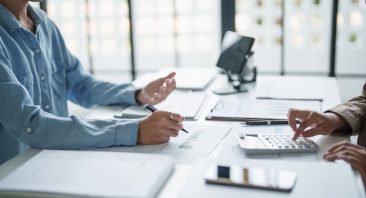 A settlement check with medical bills and a calculator on a desk, illustrating a lien on a personal injury settlement.