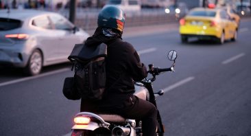 A motorcyclist rides on a highway, illustrating motorcycle lane splitting laws.