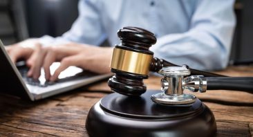 An attorney reviews medical records and case documents. This is the kind of investigation a Phoenix medical malpractice lawyer conducts to prove negligence.
