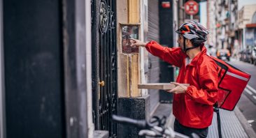 A food delivery driver presses the keycode to a building, illustrating the concept of an Uber Eats delivery driver accident.