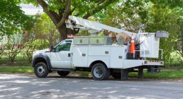 A utility bucket truck parks on a residential street — utility vehicle accidents may involve multiple liable parties.