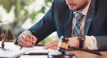 A Huntsville auto accident attorney writes a contract at their personal desk.
