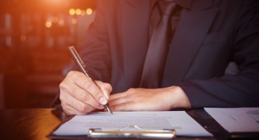 An anonymous man signs a reimbursement demand letter, illustrating how a subrogation claim reduces an injury settlement.