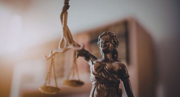 A figure of the goddess of justice with scales, illustrating how contributory negligence in Alabama can bar a claim.