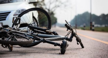 A bicycle lays on the ground in front of a car in Florida, illustrating when someone may need personal injury protection (PIP) benefits after an accident.