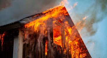 A family’s house burns, illustrating the overwhelming concept of what to do after a house fire.